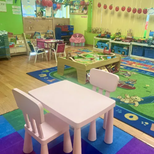 Spacious daycare classroom with green walls and play areas