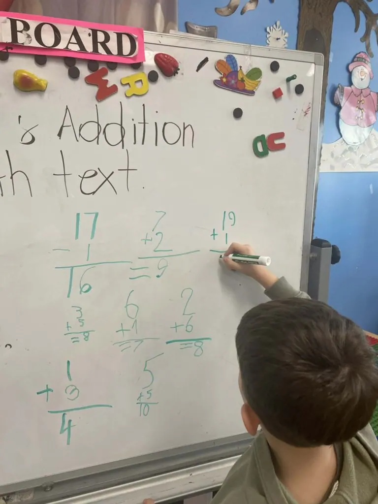 Kindergarten addition lesson on the whiteboard at Fantasy Island near Edison Park